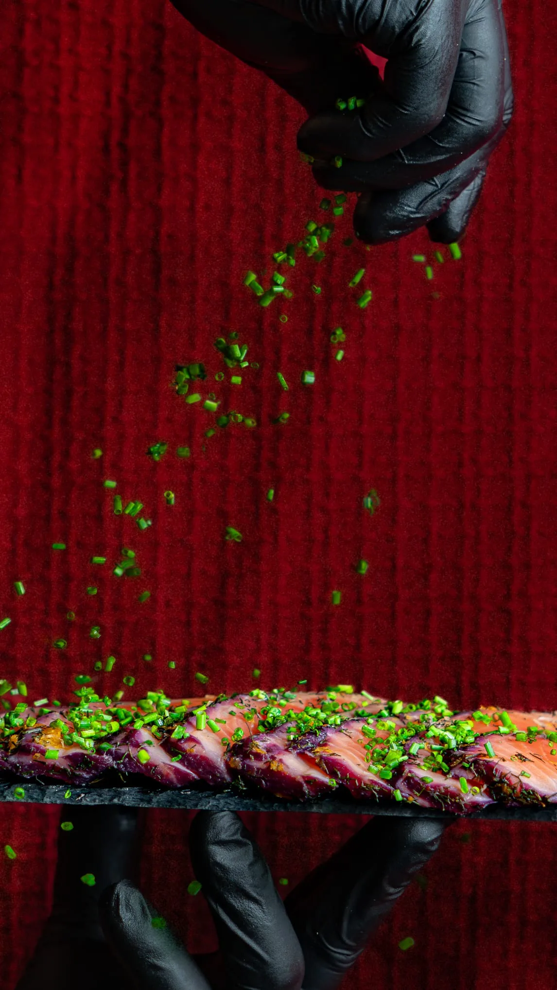Dressage du saumon gravlax — Touche finale de ciboulette sur une planche de saumon gravlax. | Traiteur Strasbourg