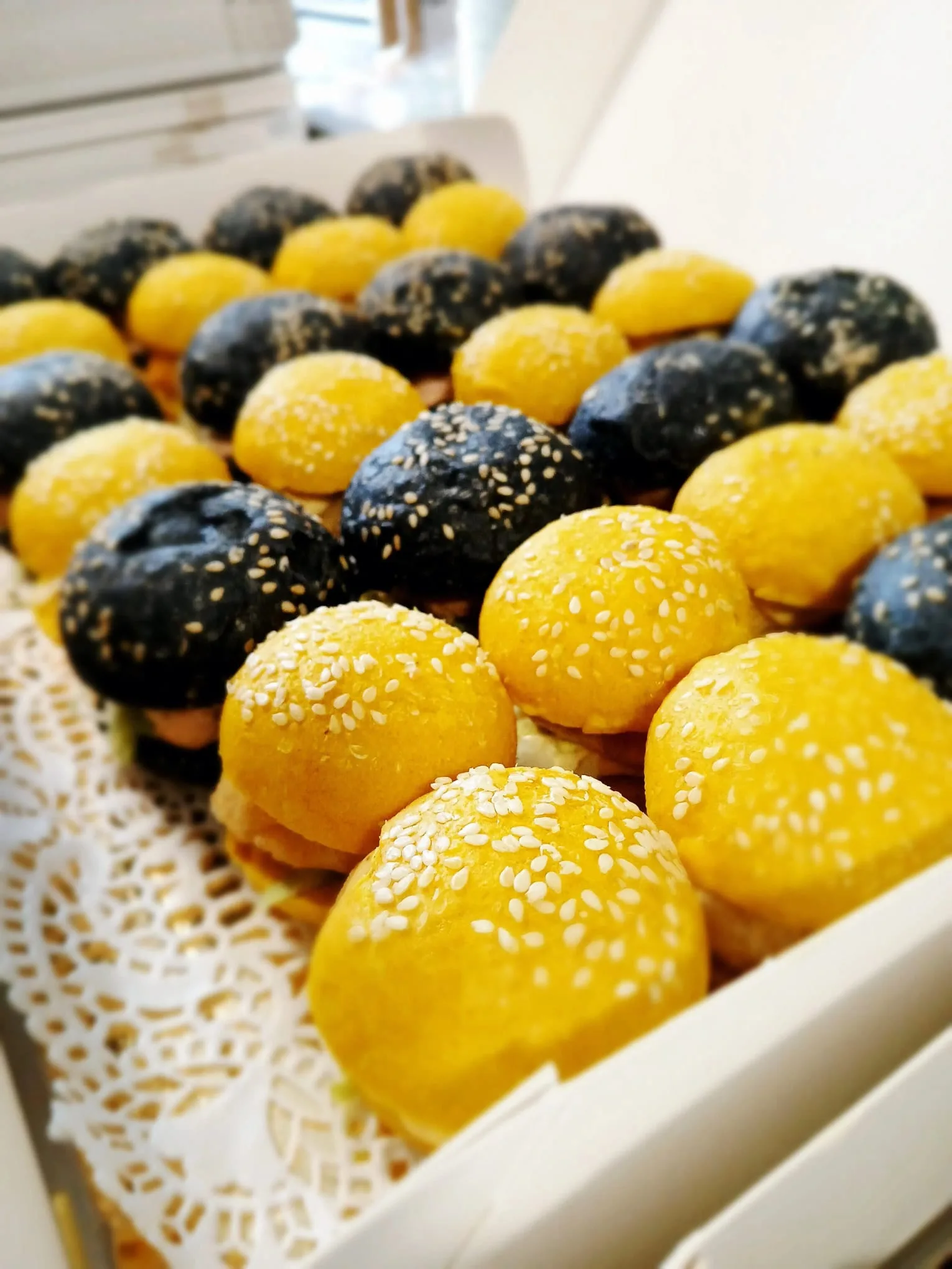 Mini-burgers — Mini-burgers aux pains noirs et jaunes parsemés de sésame. | Traiteur Strasbourg